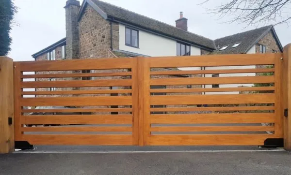 Horizontal slat driveway gate with stone pillars